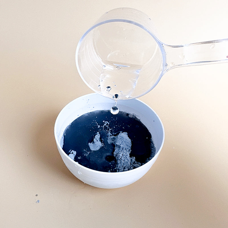 mix charcoal mask powder with a spoon of water